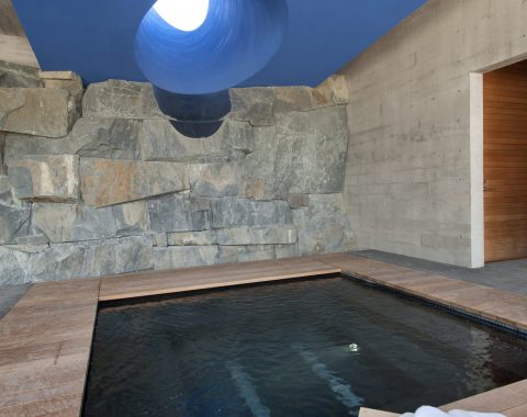 Dark green hot tub with natural rock