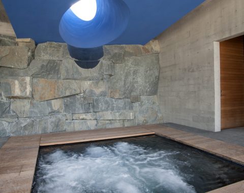 Covered hot tub surrounded by natural rock