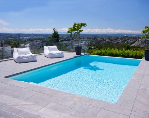 This inviting swimming pool is finished in a brilliant white plaster that beckons one to swim.