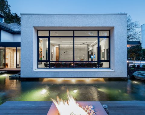 On the side of the house, the tranquil koi pond is dramatically framed by a fire feature and cozy lounge chairs that face the home.
