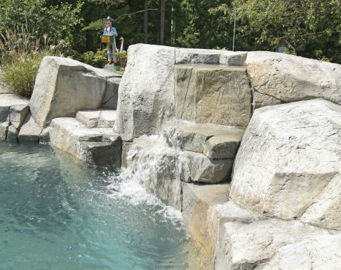 Natural swimming pool built into the face of rocks with water feature