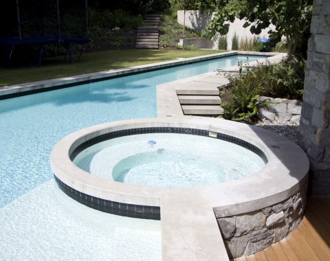 Circle shaped built in hot tub and spa surrounded by the main swimming pool
