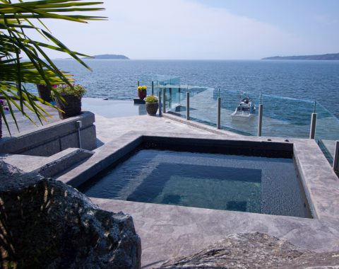 Hot tubs and spa built into the side of a backyard with natural coloured stone