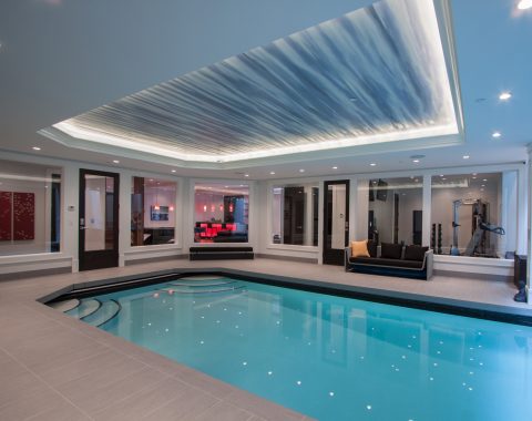 indoor swimming pool builders created a large pool with steps either side with spot lights