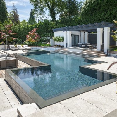 flood edge pool with wooden surround to create seamless outdoor living area