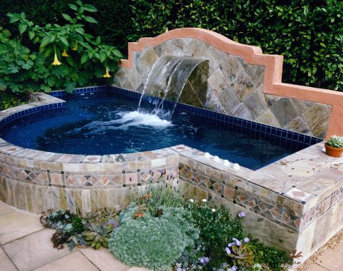 Large stand alone hot tub and spa with built in water feature