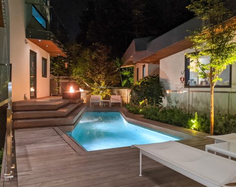 White LED lights elevate this pool to a refreshing blue when lit at night. Complements the wooden deck and bronze accents that line the poolside fire feature.