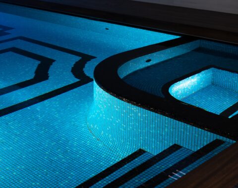 Illuminated to highlight its elegance, this tile is complemented by the striking blue glass tile for a vibrant contrast.