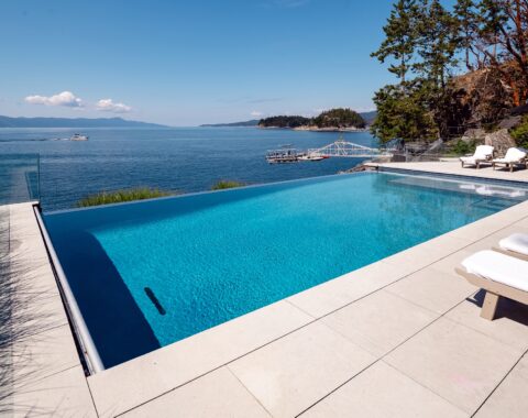 Beachfront property featuring an infinity pool with a lounging ledge to admire the breathtaking ocean views.