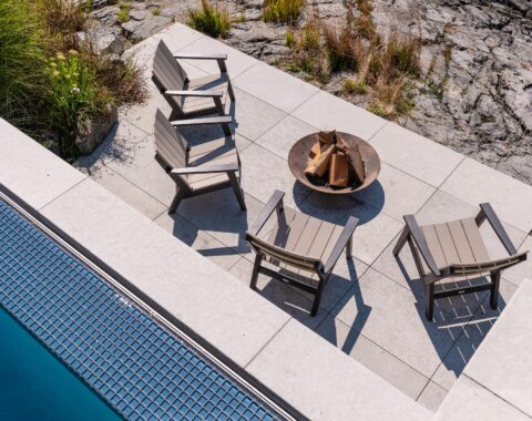 Relaxing patio area beachside complete with a fire pit and an infinity edge that acts as a water feature when viewed from this angle.
