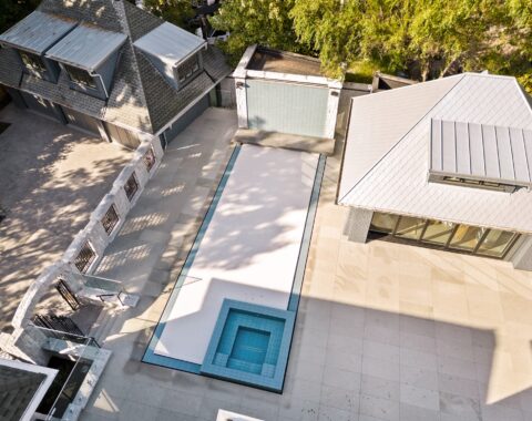 Top view of a covered pool with poolside surroundings and natural landscape.