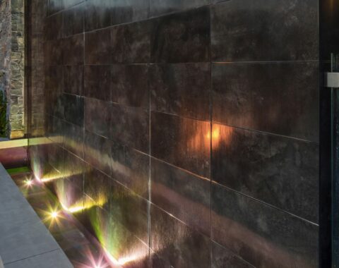 Side-angle view of a pool with an elegant waterfall feature