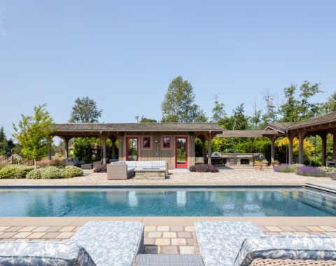 A lively and tranquil backyard oasis featuring a custom-designed pool with a perfect view for relaxation.