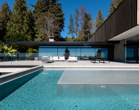 Poolside view of a luxury pool featuring a Baja shelf, minimalist design, and neutral tones.