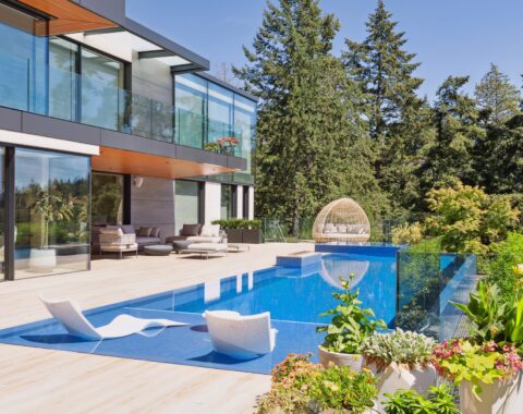Inviting modern patio featuring an inviting infinity pool. This all tile pool is split into three zones; lounging with its baja shelf and lounge chairs, lap pool for fitness and at the far end an elevated hot tub for warmth and relaxation.